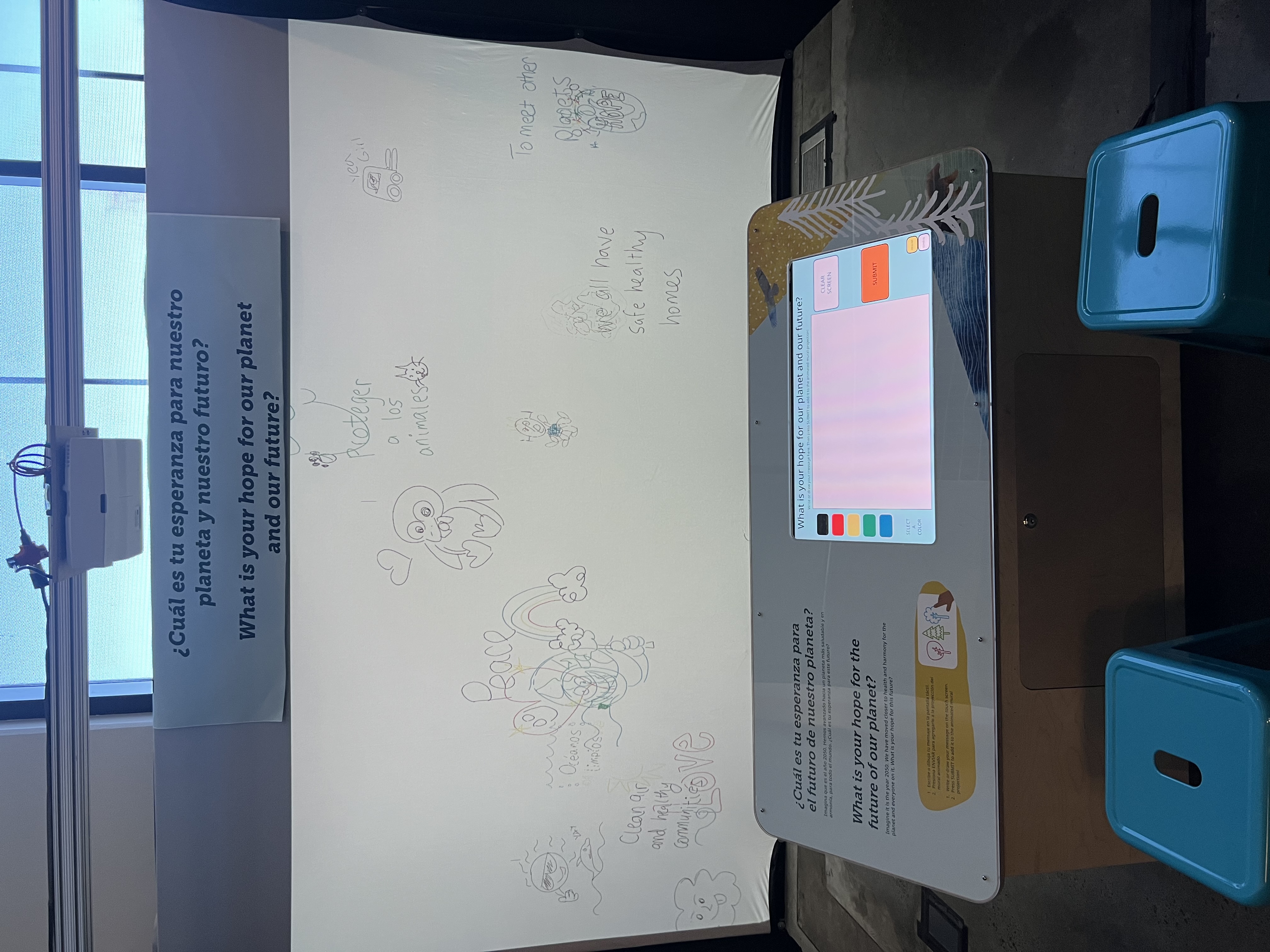 a touchscreen drawing program in front of a large projection screen.
